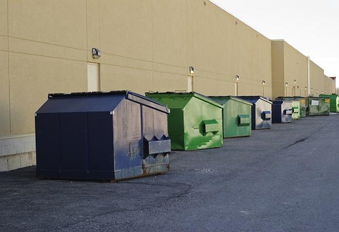 a compact construction dumpster being emptied by a waste disposal truck in El Segundo CA